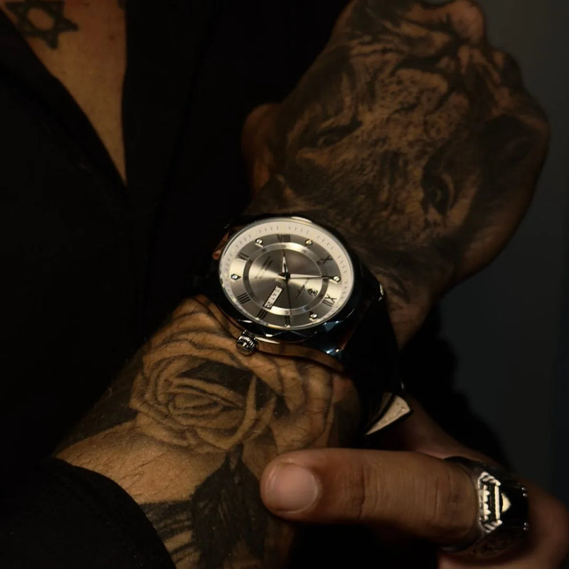 Relogio de mostrador prata e pulseira de couro preto no pulso